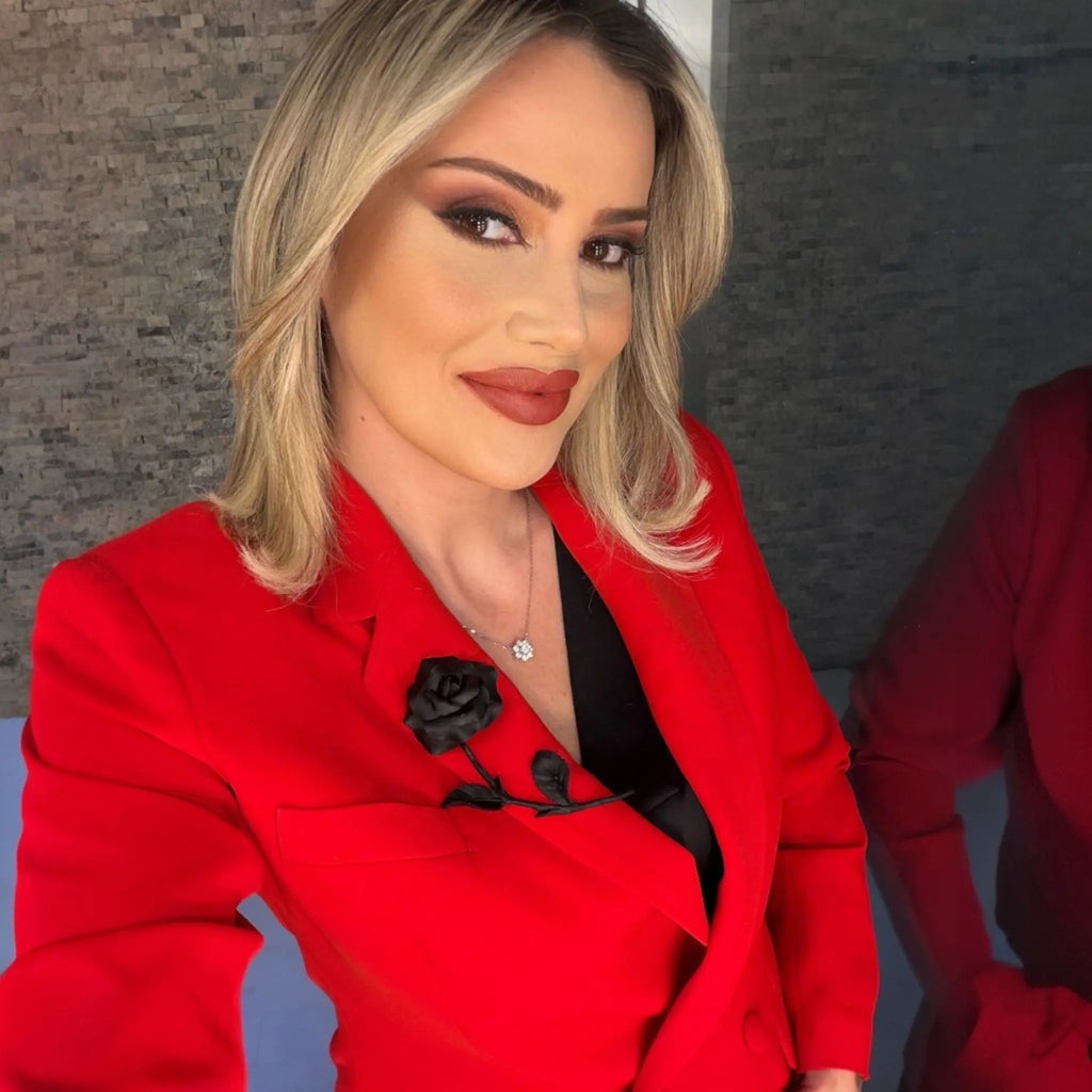 JAYA by Serap Gül el yapımı mat siyah porselen gül broşu, kırmızı ceket üzerinde zarif bir aksesuar.